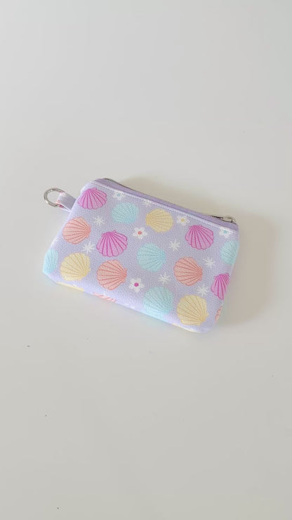 purple vegan leather coin purse with seashell pattern on a white background