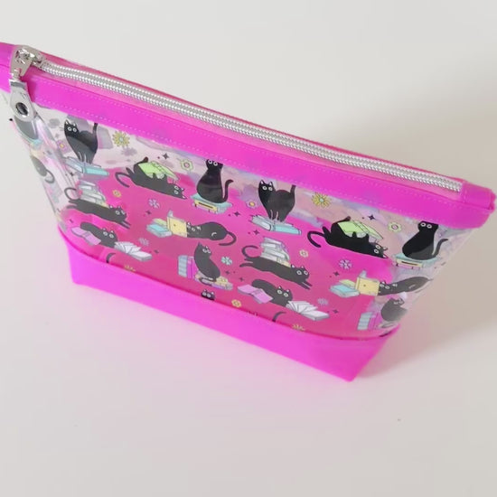 clear makeup bag with a black cat and book pattern pink bottom
