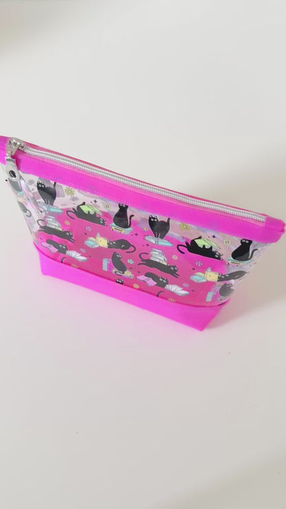 clear makeup bag with a black cat and book pattern pink bottom