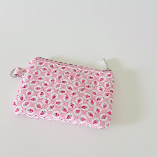 Pink strawberry coin purse on a white background