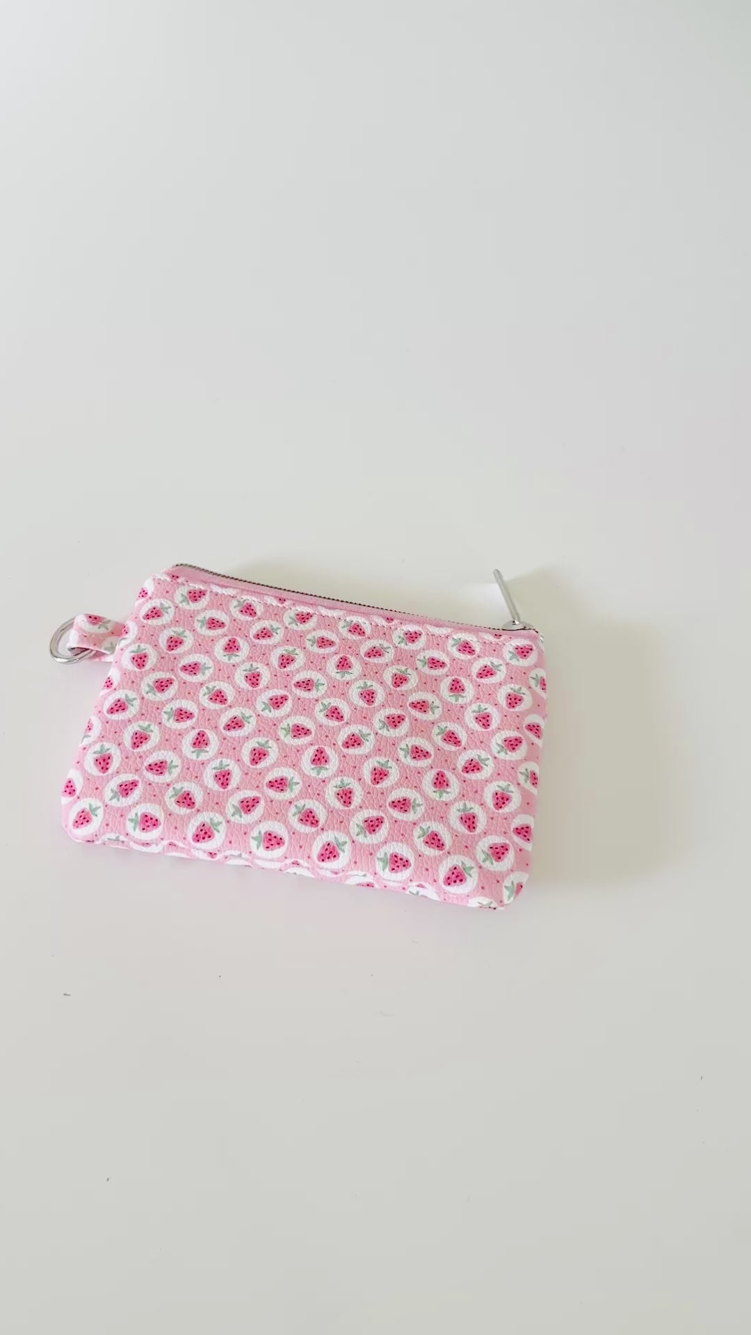 Pink strawberry coin purse on a white background