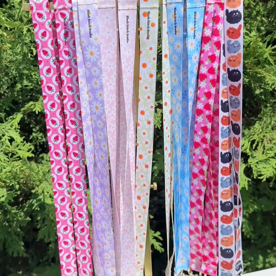Set of colorful patterned lanyards hanging on a rack 