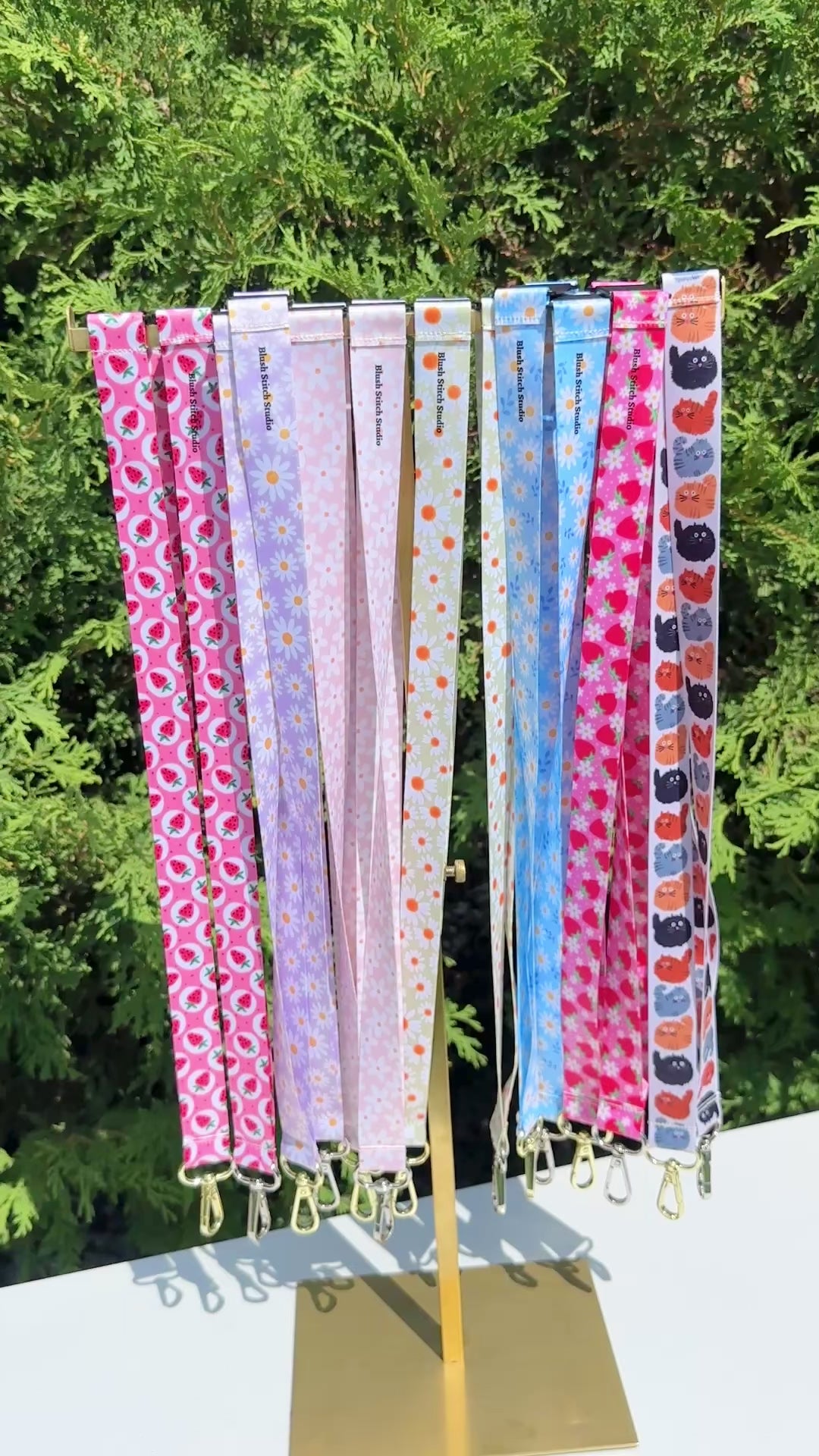 Set of colorful patterned lanyards hanging on a rack 