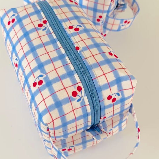 Set of 2 fabric pouches with blue plaid pattern and red cherries on a light gray background.