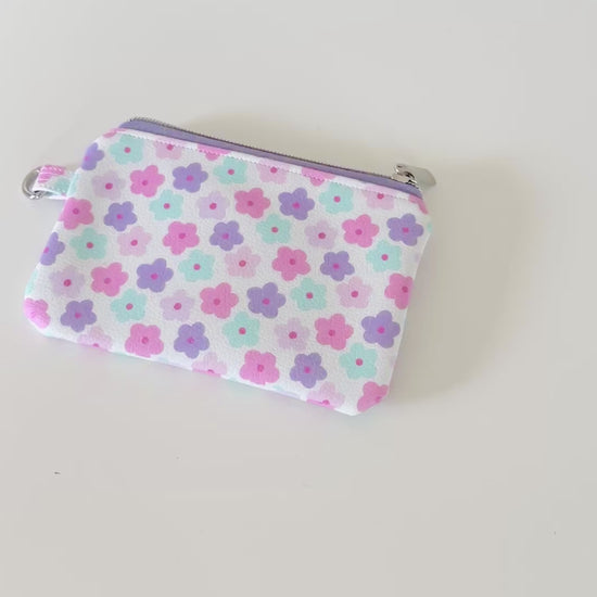 pink and purple Floral-patterned coin purse with coins and cards on a white background