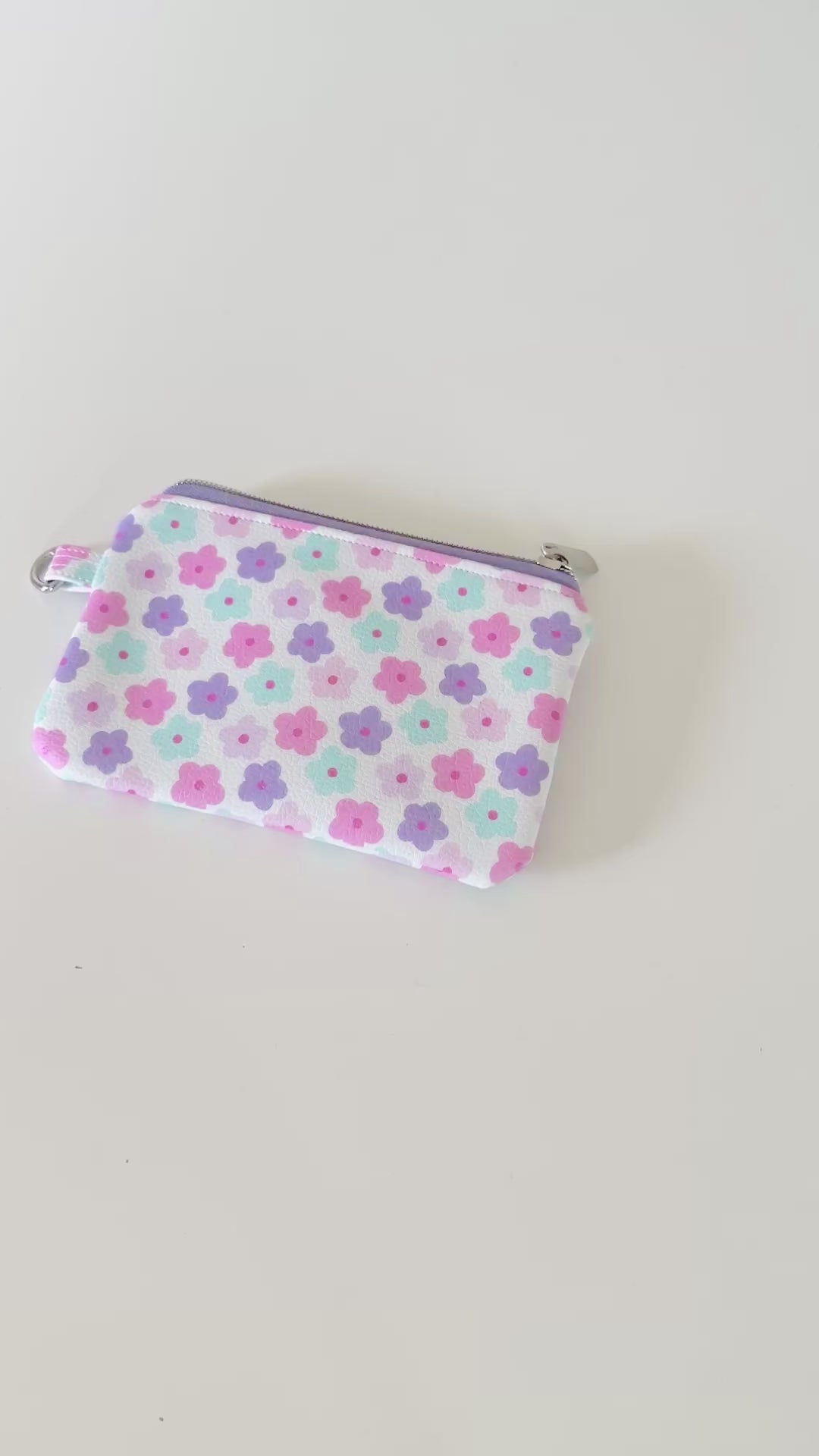 pink and purple Floral-patterned coin purse with coins and cards on a white background