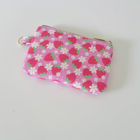 Pink strawberry coin purse  with a daisy pattern on a white background