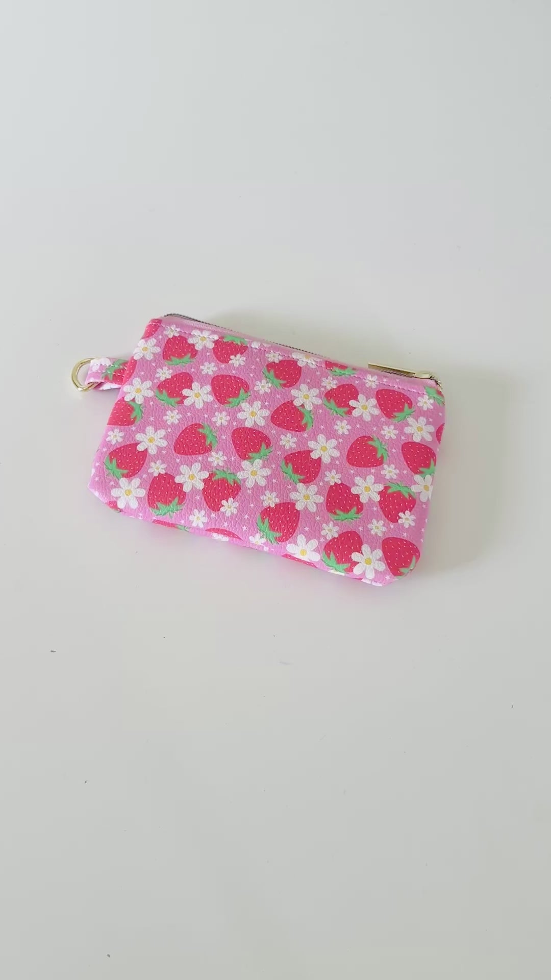 Pink strawberry coin purse  with a daisy pattern on a white background