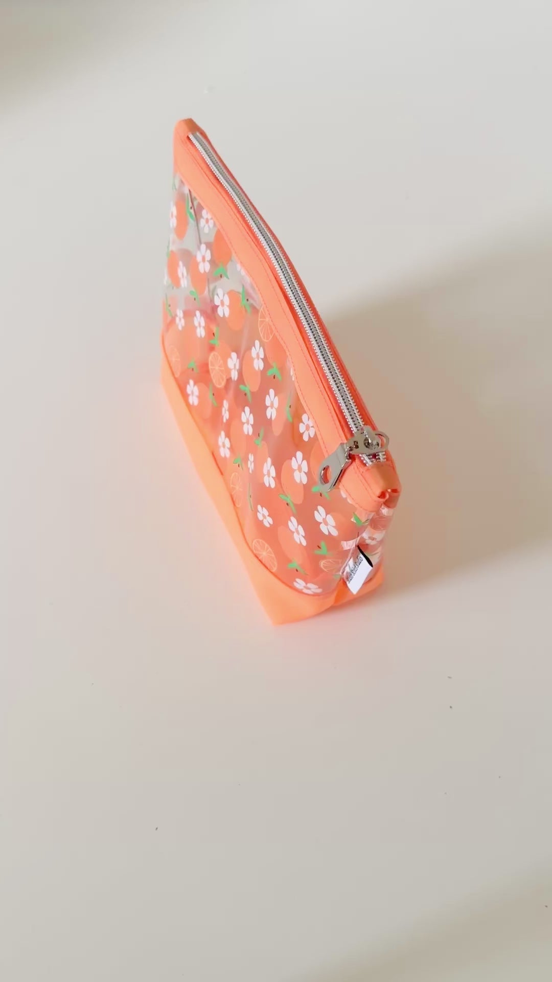 Clear pouch with white floral pattern on a light gray background
