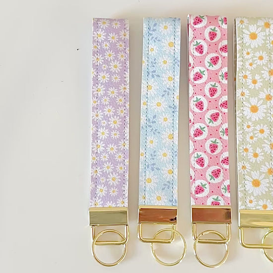 Set of floral patterned keychains with gold clasps on a white background