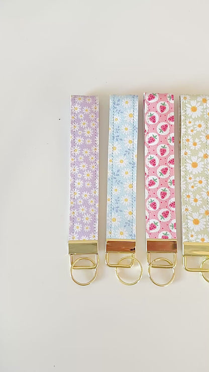 Set of floral patterned keychains with gold clasps on a white background