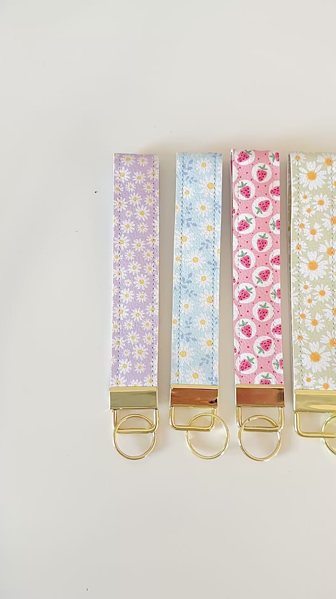 Set of floral patterned keychains with gold clasps on a white background