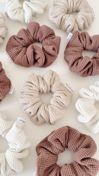 Three neutral waffle textured scrunchies in beige, brown, and light brown on a white background.