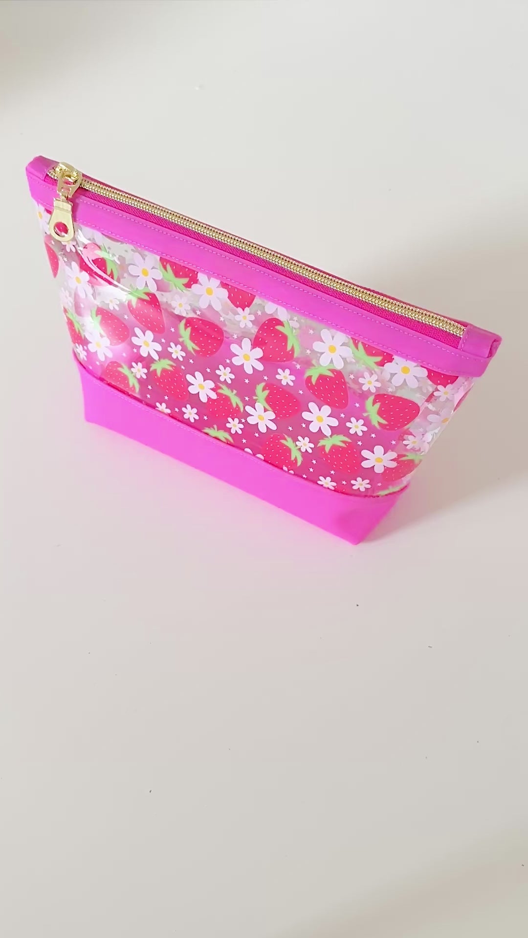 clear makeup bag with a pink strawberry pattern