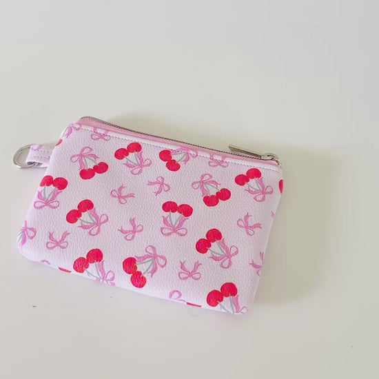 vegan leather coin purse with cherry bow pattern on a white background