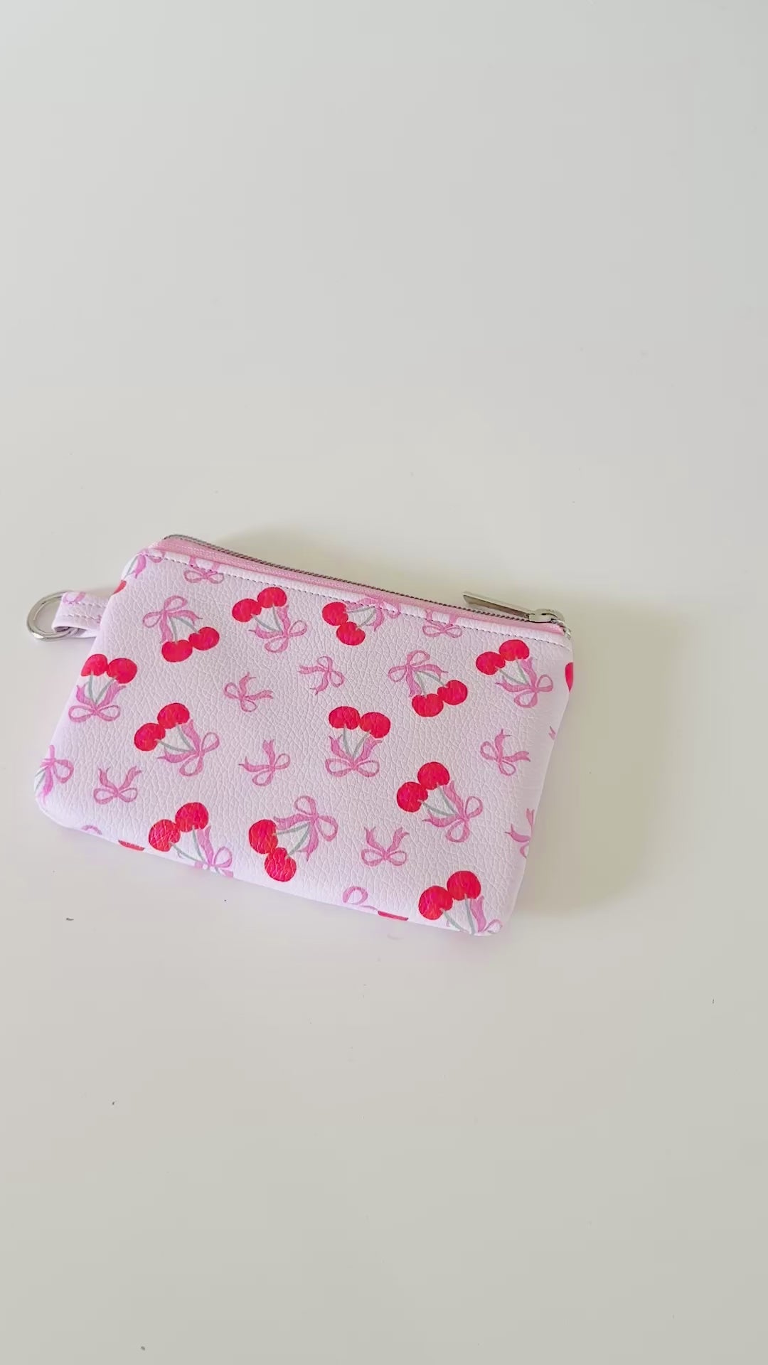 vegan leather coin purse with cherry bow pattern on a white background