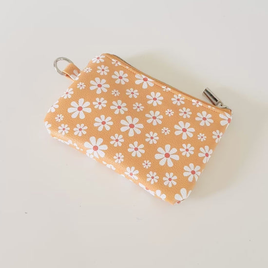 mustard Yellow coin purse with white floral pattern on a white background