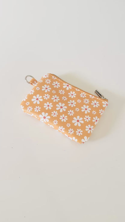 mustard Yellow coin purse with white floral pattern on a white background
