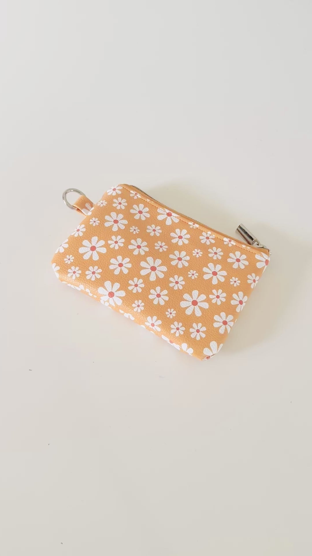 mustard Yellow coin purse with white floral pattern on a white background