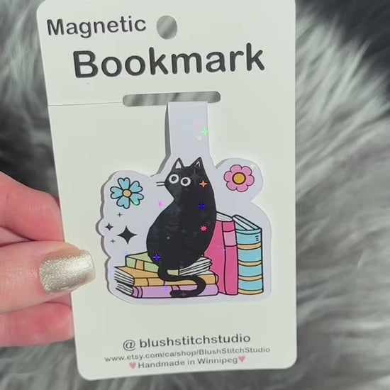 Magnetic bookmark with a black cat design on a gray textured background